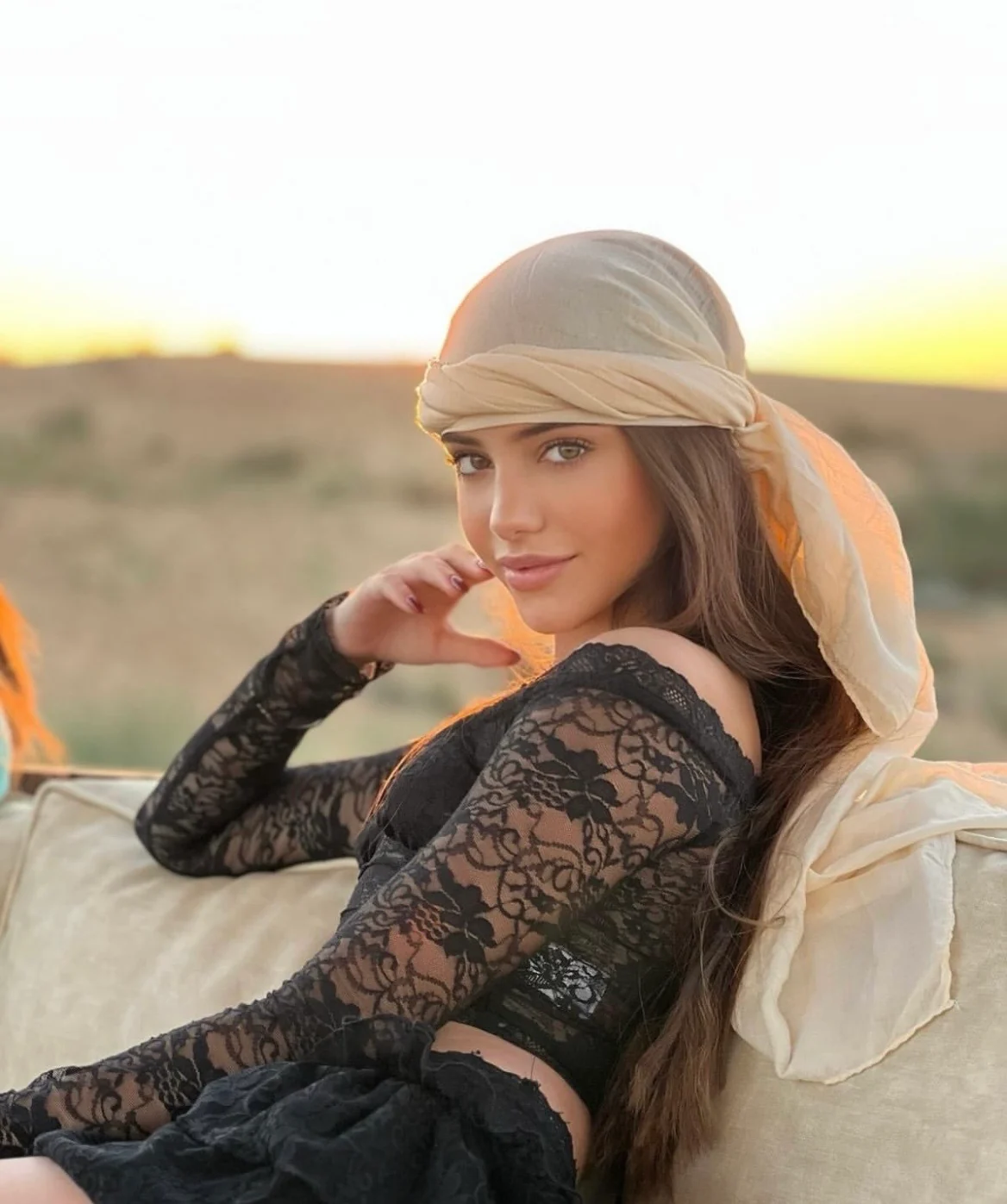 Mila in warm evening light with a sandy landscape behind her